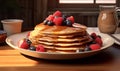 Plate with tasty pancakes and berries on wooden table in room, closeup