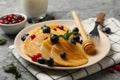 Plate of tasty pancakes berry on gray table. Composition of sweet breakfast