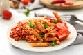 Plate with tasty penne pasta and bolognese sauce on table Royalty Free Stock Photo