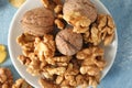 Plate with tasty walnuts on color table, closeup Royalty Free Stock Photo
