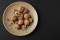 Plate with tasty walnuts on dark background Royalty Free Stock Photo