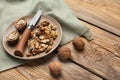 Plate with tasty walnuts and knife on wooden table Royalty Free Stock Photo