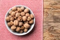 Plate with tasty walnuts on wooden table Royalty Free Stock Photo