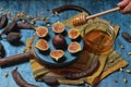 Plate with three cut figs and one whole and container with honey Royalty Free Stock Photo