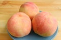 Plate of Three Fresh Ripe Peaches on Wooden Table Royalty Free Stock Photo