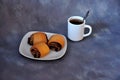 Plate with three puff pastries with poppy seeds on a gray abstract background