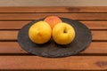 Plate with three ripe yellow peaches on woode Royalty Free Stock Photo