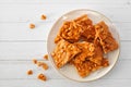 Plate of traditional peanut brittle candy pieces, top view on white wood Royalty Free Stock Photo