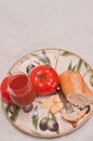 Plate with two, ripe, local, freshly picked, beef steak tomatoes with a chuck of aged cheese, a section of freshly baked baguette, Royalty Free Stock Photo