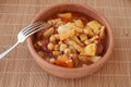 Mondongo a la espanola or cayos a la espanola. Presented in an earthenware bowl, on a wooden table View at 45 degrees