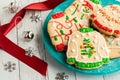 A plate of ugly Christmas sweater cookies with decorations to the left. Royalty Free Stock Photo