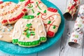 A plate of ugly Christmas sweater cookies with festive crackers to the right.