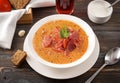 Plate of Ukrainian red borscht with parsley and sour cream on a dark wooden background, a spoon, pieces of bread ,a glass of juice Royalty Free Stock Photo