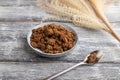 Plate with unrefined cane sugar on gray wooden. side view, close up Royalty Free Stock Photo