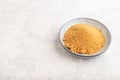 Plate with unrefined golden cane sugar on gray concrete. side view, copy space Royalty Free Stock Photo