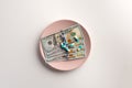 A plate with US dollar bank note and pills isolated on white Royalty Free Stock Photo
