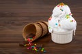 Plate of vanilla ice cream scoop swith sprinkles and waffle cones on wooden background with copy space Royalty Free Stock Photo