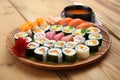a plate with a variety of sushi rolls on a bamboo mat