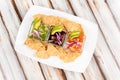 a plate with Various types of ceviche with avocado, onion and Mexican-style