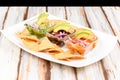 a plate with Various types of ceviche with avocado, onion and Mexican-style