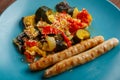 A plate of vegetables tomatoes zucchini eggplant with grilled sausages close-up. Royalty Free Stock Photo