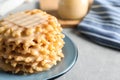 Plate of waffles and condensed milk on grey table, closeup with space for text Royalty Free Stock Photo