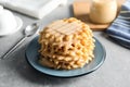 Plate with waffles and condensed milk on grey table Royalty Free Stock Photo