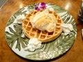 Plate with Waffles, Ice Cream, and Whipped Cream, with a Purple Flower Royalty Free Stock Photo