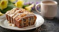 A plate of warm banana bread drizzled with a creamy coconut glaze and served with a cup of creamy earl grey tea