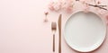 plate on white table, pink flowers, fork and knife Royalty Free Stock Photo