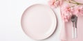 plate on white table, pink flowers, fork and knife Royalty Free Stock Photo