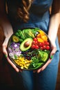 Plate in woman hands of delicious salad with different vegetables, top view. clean eating