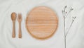 Plate wooden, spoon wooden and fork wooden with Limonium dry flower on white cloth. Mock-up of kitchenware. Top view of Table Royalty Free Stock Photo