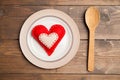 Plate on wooden table with red checked tablecloth