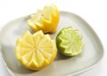 Plate with Yellow Lemon, citrus limonum and Green Lemon, citrus aurantifolia Royalty Free Stock Photo