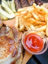 Plateau with assorted grilled pork dishes fries pickles and sauces