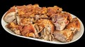 Plateful of freshly spit roasted pork shoulder slices served on oblong porcelain platter isolated on black background Royalty Free Stock Photo