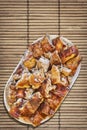 Plateful Of Freshly Spit Roasted Pork Slices Set On Vintage Rustic Slatted Bamboo Place Mat