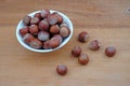 Plateful of Hazelnuts Nuts and Spilled Hazelnuts on Wooden Background