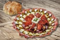 Plateful Of Serbian Appetizer Meze With Pitta Bread Loaf Set On Wooden Chipboard Table Surface