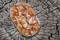 Plateful Of Spit Roasted Pork Meat Slices Set On Old Weathered Cracked Stump Picnic Table