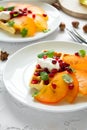 Plates of Belgian waffles with persimmon, pomegranate seeds and sour cream Royalty Free Stock Photo