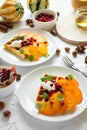 Plates of Belgian waffles with persimmon, pomegranate seeds and sour cream Royalty Free Stock Photo