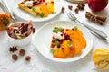 Plates of Belgian waffles with persimmon, pomegranate seeds and sour cream Royalty Free Stock Photo