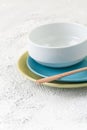 Plates, bowl and wooden spoon on a light gray textural background Royalty Free Stock Photo