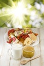 Plates with cookies, cup with milk and honey on the table Royalty Free Stock Photo