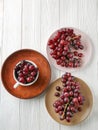 Plates and cup with sweet grapes on white wooden table Royalty Free Stock Photo