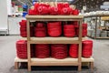Plates and cups are sold at the store. Rows of different red kitchen utensils for home on shelves in a mall Royalty Free Stock Photo