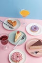 Plates with delicious cheesecake and glass with a drink on a pink background