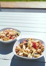 Plates with fresh fruit salad, Granola and berries in the morning on the veranda Royalty Free Stock Photo